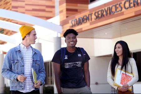 Happy students walking by Student Services Center